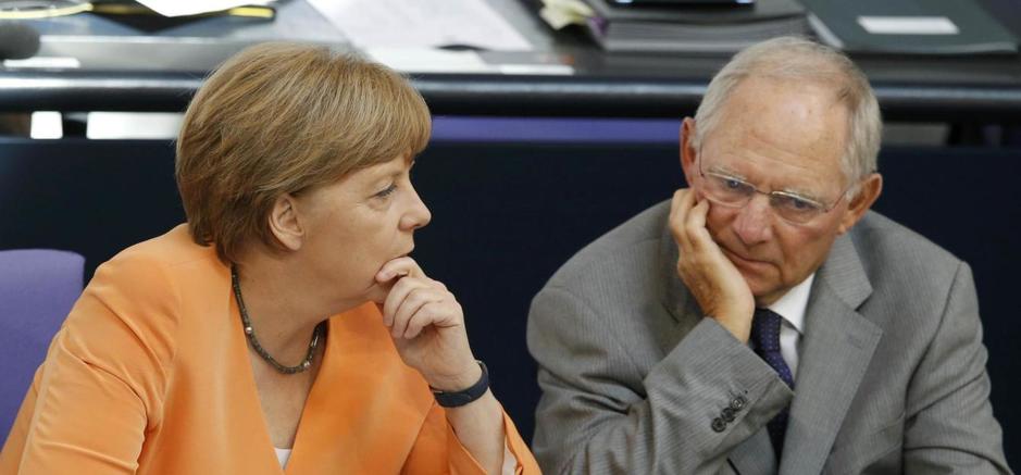 german-chancellor-merkel-speaks-with-finance-minister-schaeuble-during-a-parliamentary-debate-on-the-greek-debt-crisis-at-the-german-lower-house-of-parliament-bundestag-in-berlin